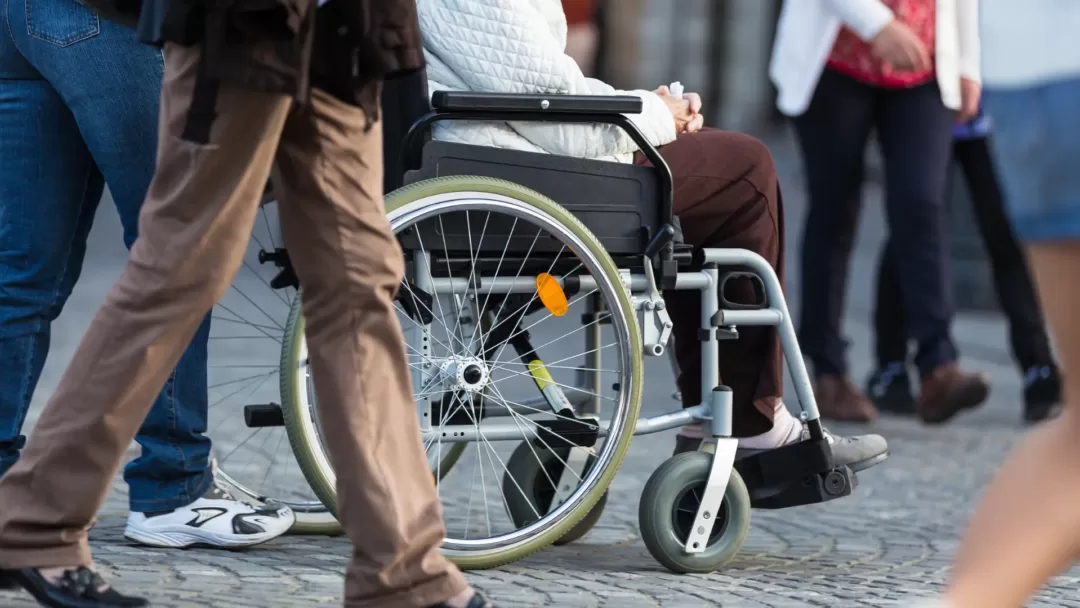 A person seated in a wheelchair. Such individuals are examples of those greatly helped by Performance Solution Reports, which improve their access.